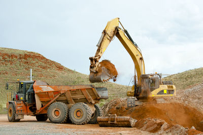 Bulldozer and truck at construction site 