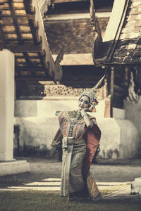 Portrait of beautiful woman wearing traditional clothing against building