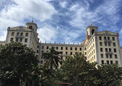 Low angle view of palm trees and buildings