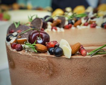 Close-up of fruit and nut decoration on top of chocolate cake. 