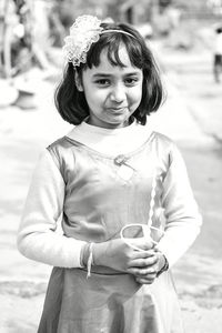 Portrait of cute girl holding toy while standing outdoors