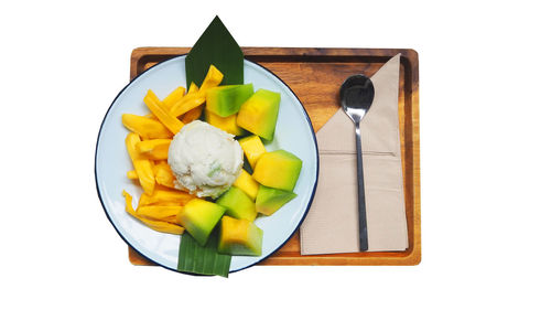 High angle view of fruits in plate against white background