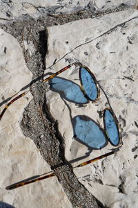 High angle view of eyeglasses on rock