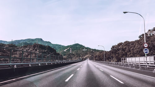 Road by mountain against sky