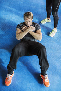 High angle view of man doing sit-ups at gym
