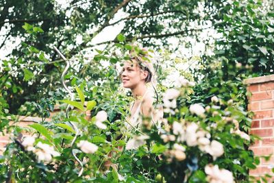 Young woman standing amidst trees