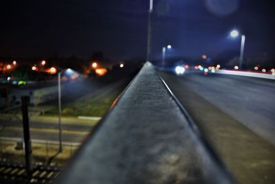 Illuminated road against sky at night