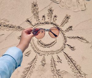 Sunglasses smiley sun at sandy beach