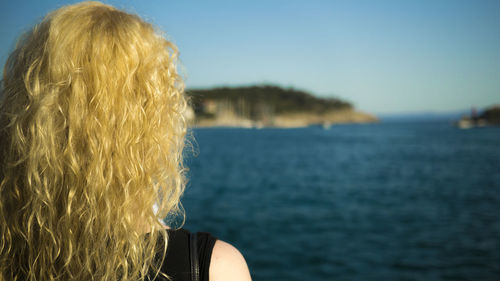 Rear view of woman looking at sea against sky