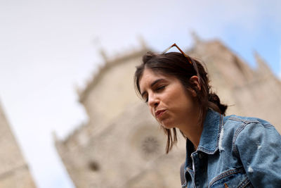 Woman with closed eyes against buildings