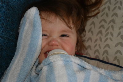 Close-up of boy drinking milk while lying on bed