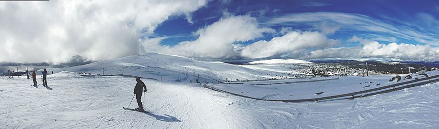 People skiing on snow covered landscape