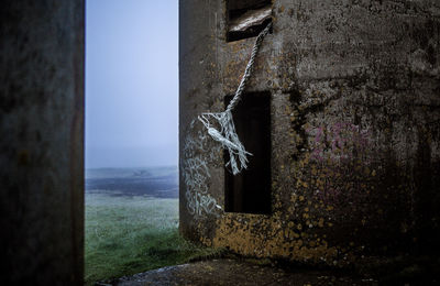 Old abandoned building by sea against sky