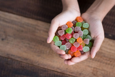 Close-up of hands holding colorful candies over table