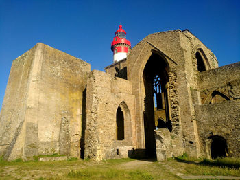 Low angle view of old building against clear blue sky