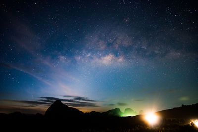 Scenic view of silhouette mountains against sky at night