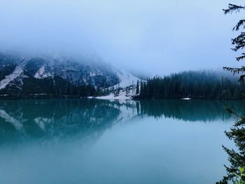 Scenic view of lake by snowcapped mountains against sky