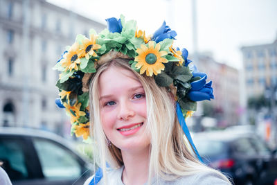 Rome, italy - may 22, 2022 a pretty blonde ukrainian girl wearing colorful flower crown wreath at