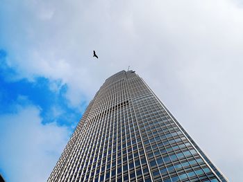 Low angle view of international finance centre against cloudy sky in city