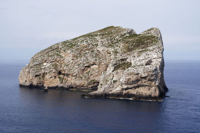 Rock formations in sea against sky