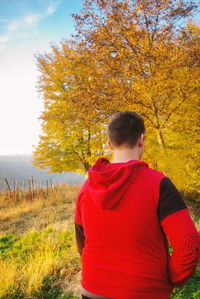 Rear view of man standing on field during autumn