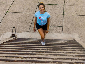 Portrait of young woman standing on steps
