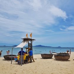 People on beach against sky