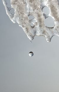 Close-up of frozen water in winter against sky