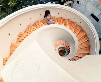 High angle view of woman sitting on spiral staircase