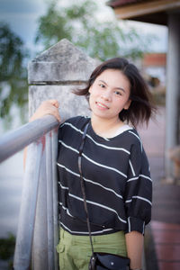 Portrait of smiling young woman standing outdoors