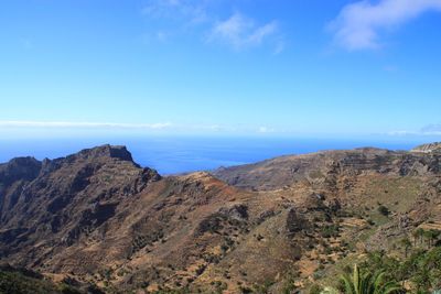 Scenic view of rocky mountains against blue sky