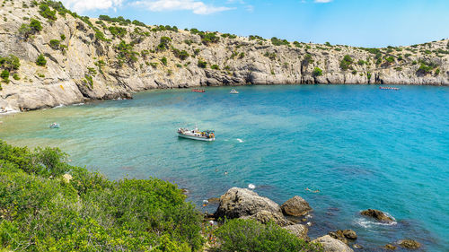 High angle view of people on rock in sea