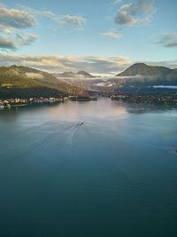 Sunset in the mountains with lake in the foreground and boat on the lake