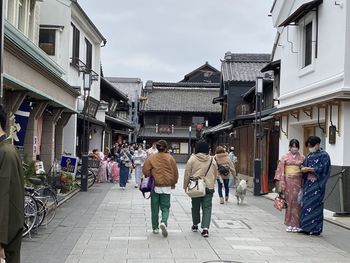 Rear view of people walking on street in city