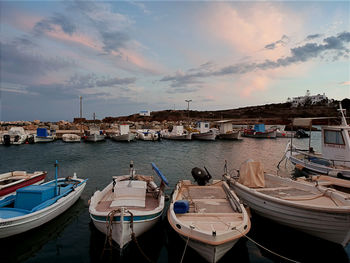 Boats moored at harbor during sunset