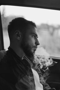 Young man looking through window