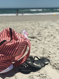 Close-up of shoes on beach