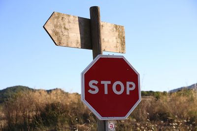 Close-up of road sign against clear blue sky