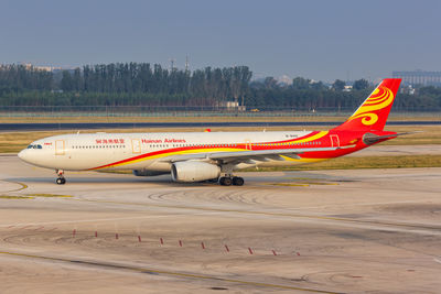 View of airplane on airport runway against sky