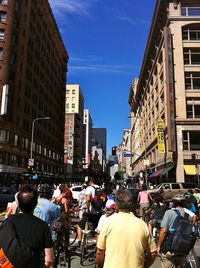 People on street in city against sky
