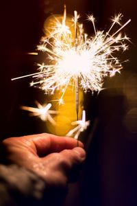 Close-up of hand holding sparkler at night