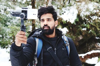 Man photographing on snow covered field