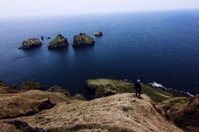 High angle view of man on cliff by sea