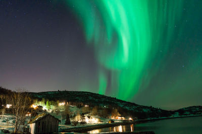 Illuminated buildings against sky at night