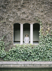 Low angle view of woman standing by window