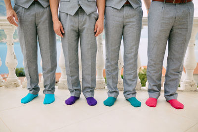 Low section of people standing on tiled floor