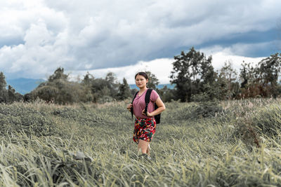 Portrait of man standing on field against sky