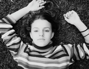 Directly above shot of teenage girl lying on grassy field