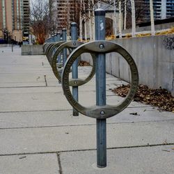 Bicycle parked on footpath by building in city during winter