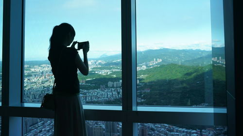 Woman photographing through window